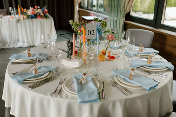 Modern stylish wedding table setting. Italian summer style. The wedding decor. The pastel colors flowers bouquet. Natural beautiful wedding decorations. Minimalistic wedding decorations