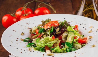 Fresh vegetable salad with pumpkin seeds on wooden table