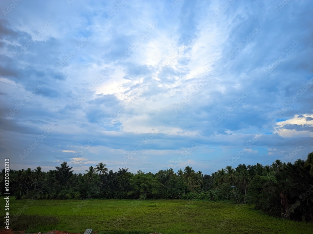 Wall mural the photo depicts a beautiful landscape with a dramatic sky. the sky is divided into two distinct pa