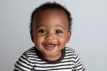 Smiling baby with striped shirt showing first teeth against white background Generative AI