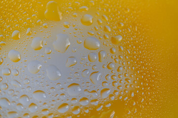 黄色背景のガラスに着いた水滴