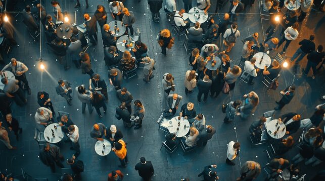 A vibrant crowd mingles at a bustling event, viewed from above, creating a dynamic tapestry of social interactions.