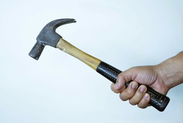 Isolated steel hammer with black handle, held in a carpenter's hand, ready for construction work on...