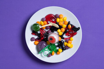 Assortment of Halloween candies isolated on purple background