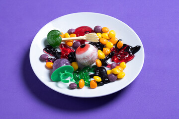 Assortment of Halloween candies isolated on purple background