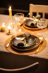 winter holidays, dinner party and celebration concept - close up of scandinavian christmas table serving with burning candles at home at night