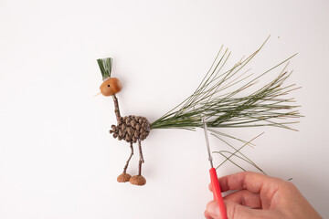 step in creative process, DIY, autumn craft, handmade bird crafted from pine cones and twigs, a...