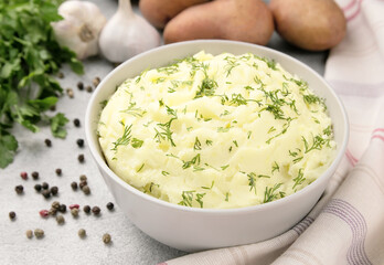 Mashed potatoes in white bowl on grey concrete background. Healthy food