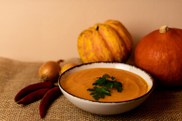 A bowl of pumpkin soup on the table. Autumn vegetables. Homemade food