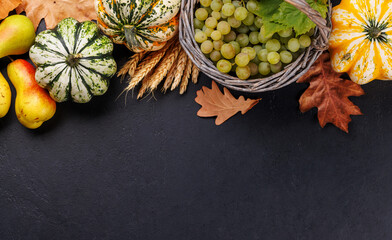 Autumn-themed food arrangement with pumpkins, pears, grapes, and autumn leaves