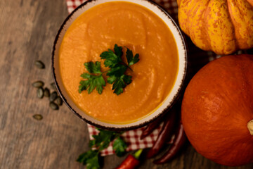 A bowl of pumpkin soup on the table. Autumn vegetables. Homemade food