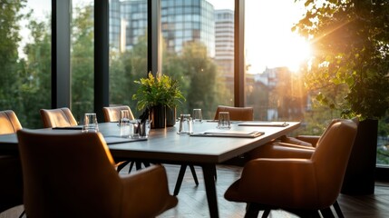 An elegant meeting room with polished furnishings, large windows offering a city view, and lush plants, bathed in sunset light providing a warm professional ambiance.