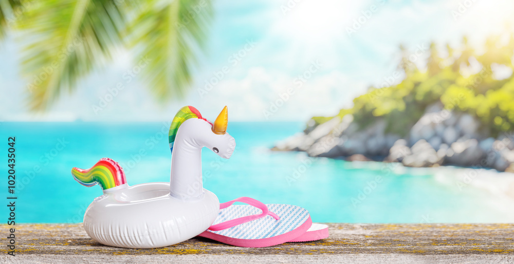 Poster lip flops and a floating flamingo placed on a table with a sunny sea