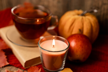 Autumn composition, tea, pumpkins, candle on the table. Autumn comfort at home