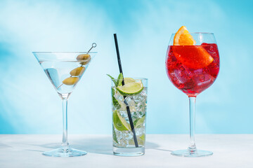 A variety of cocktails arranged on a table against a light blue background