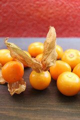 Heap of vibrant yellow ripe Cape Gooseberries on wooden table