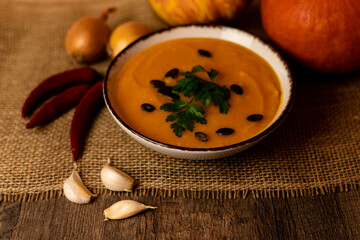 A bowl of pumpkin soup on the table. Autumn vegetables. Homemade food