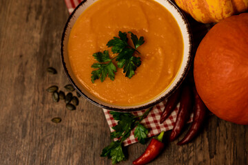 A bowl of pumpkin soup on the table. Autumn vegetables. Homemade food