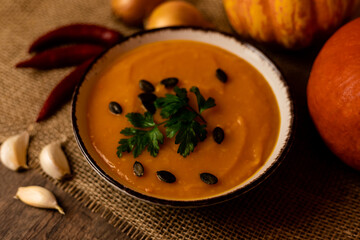 A bowl of pumpkin soup on the table. Autumn vegetables. Homemade food