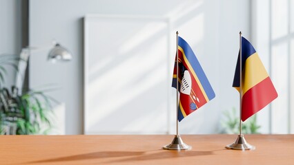 FLAGS OF ESWATINI AND ROMANIA ON TABLE