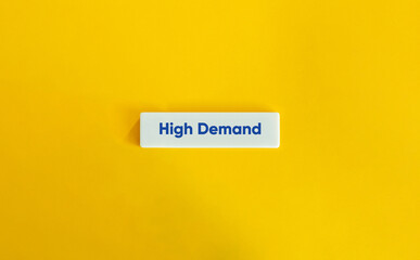 High Demand Term. Blue Text on Block Letter Tile on Yellow Background.