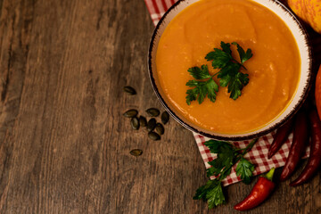 A bowl of pumpkin soup on the table. Autumn vegetables. Homemade food