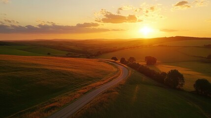 Fototapeta premium A peaceful countryside view with rolling hills, a winding road, and a colorful sunset, capturing the beauty of rural travel