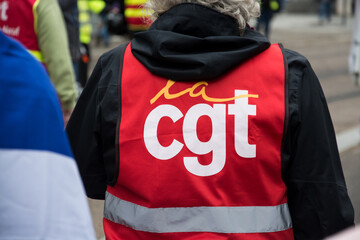 Mulhouse - France - 5 october 2024 - Portrait on back view of  people protesting in the street with a red CGT syndicate jacket