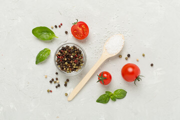 Fresh tomatoes, basil, sea salt and spices on concrete background, top view