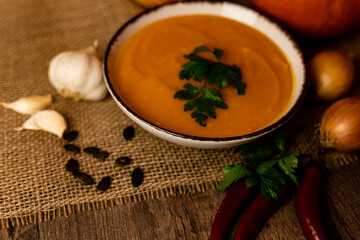 A bowl of pumpkin soup on the table. Autumn vegetables. Homemade food