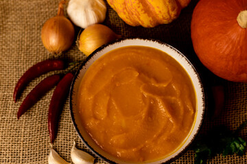 A bowl of pumpkin soup on the table. Autumn vegetables. Homemade food