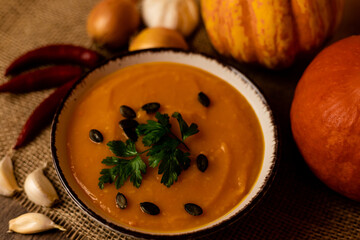 A bowl of pumpkin soup on the table. Autumn vegetables. Homemade food