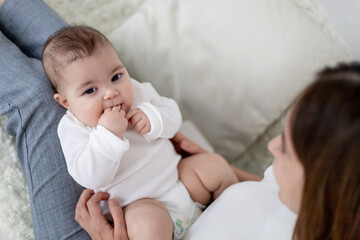 baby close-up in mom's arms in a heavy body, maternal love and care, portrait