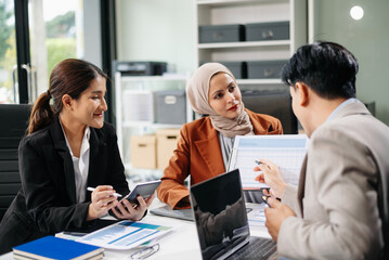 Office colleagues have a casual discussion. During a meeting in a conference room, a group of business teem