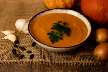 A bowl of pumpkin soup on the table. Autumn vegetables. Homemade food