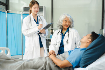 Doctor talking with man patient for monitoring and check up after surgery. doctor touching patient hand and consoling.