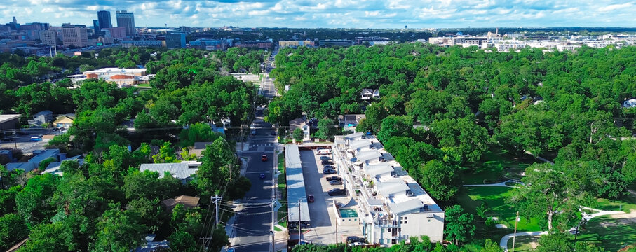 Panorama aerial view lush green park side business park and residential neighborhood along Waller Street North of Austin, Texas Capital City, downtown skyscraper, office building in background