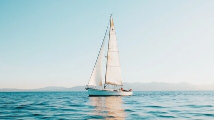 Fototapeta premium A picturesque sailboat on a serene blue lake, flanked by mountain ranges under a clear sky. The water is still, creating a perfect reflection. Great for travel inspiration.