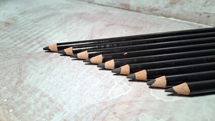 Row of vintage black crayons with close-up and copy space