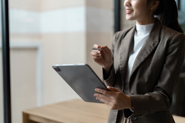 Confident Businesswoman Holding Tablet in Modern Office Setting for Professional Success and Innovation