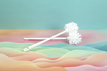 a duo of toilet brushes in front of wave background.