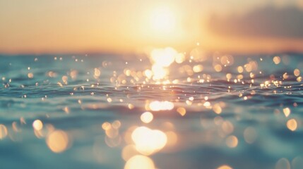 The sun descends towards the horizon, casting a warm glow on the ocean surface, as gentle waves create a sparkling effect in the evening light