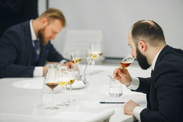 Professional sommelier sniffing unknown whiskey during blind tasting. Sommelier exam to study different wine and whiskey.