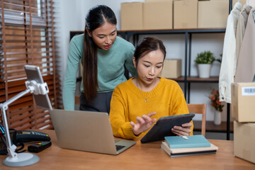 Young Entrepreneurs Managing Online Fashion Store from Home Office Using Laptop and Tablet for Marketing and Logistics