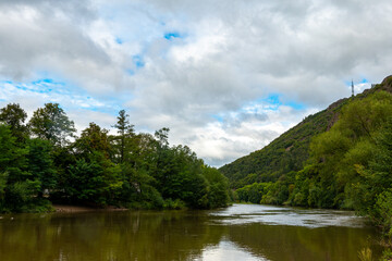 A scenic view of a river flowing through a valley on a cloudy day