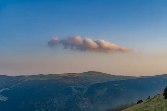 nuve aislada con luz de puesta de sol y paisaje de monta&ntilde;a