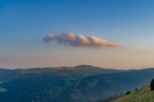 nuve aislada con luz de puesta de sol y paisaje de monta&ntilde;a