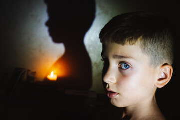 War and blackout in Ukraine. Portrait of a teenager in a city flat during a blackout. Burning...
