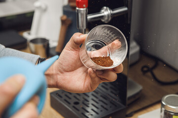 Barista Cleans Ground Coffee from Excess Husks and Particles using an Air 