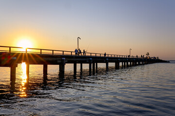 Fototapeta premium Sunset jetty silhouette, Kingfisher Bay, K'gari Queensland, coastal lifestyle, fishing camping weekend summer holiday vacation